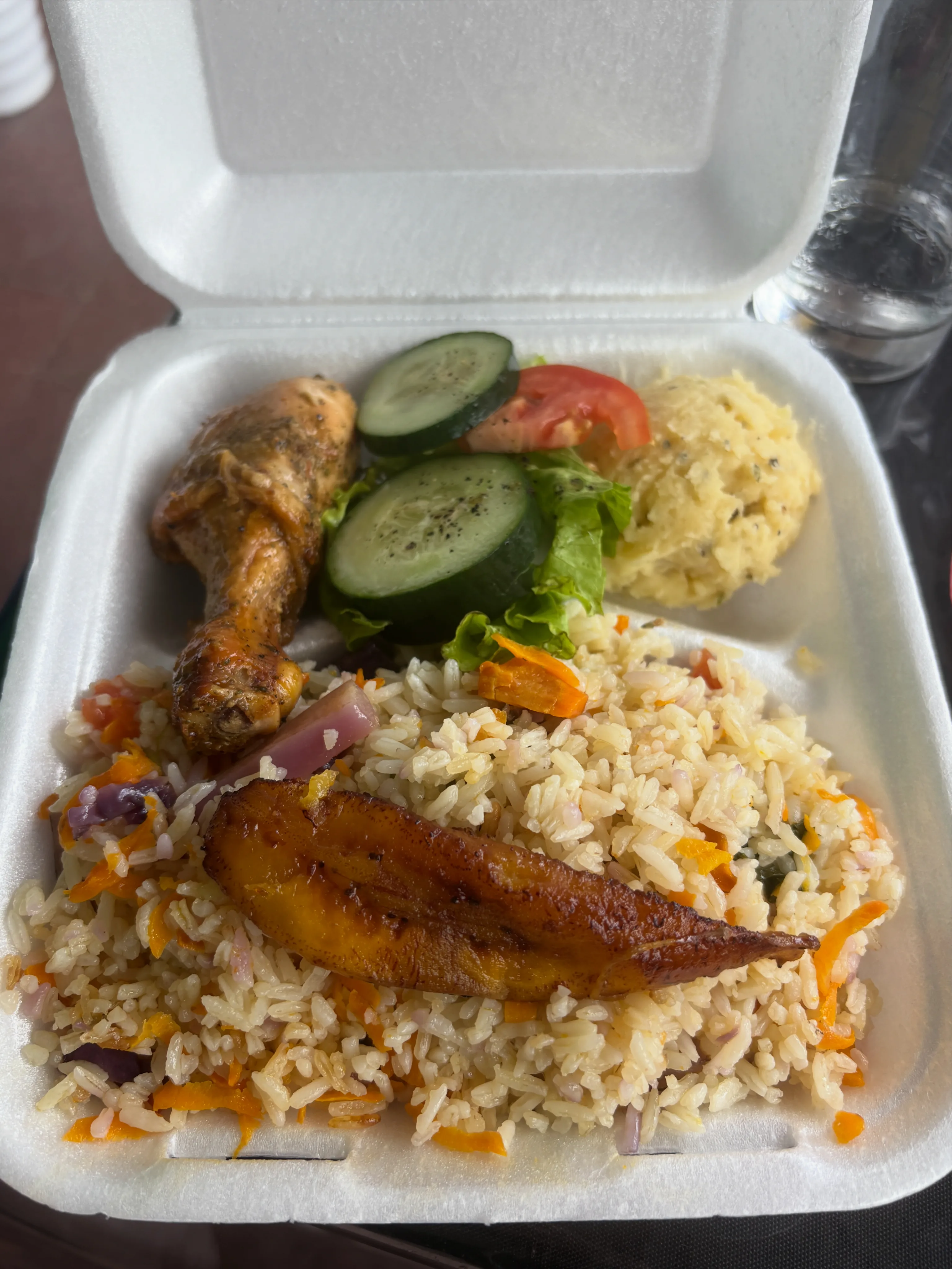 Caja para llevar con pollo, arroz, plátano maduro, ensalada y puré de papa.
