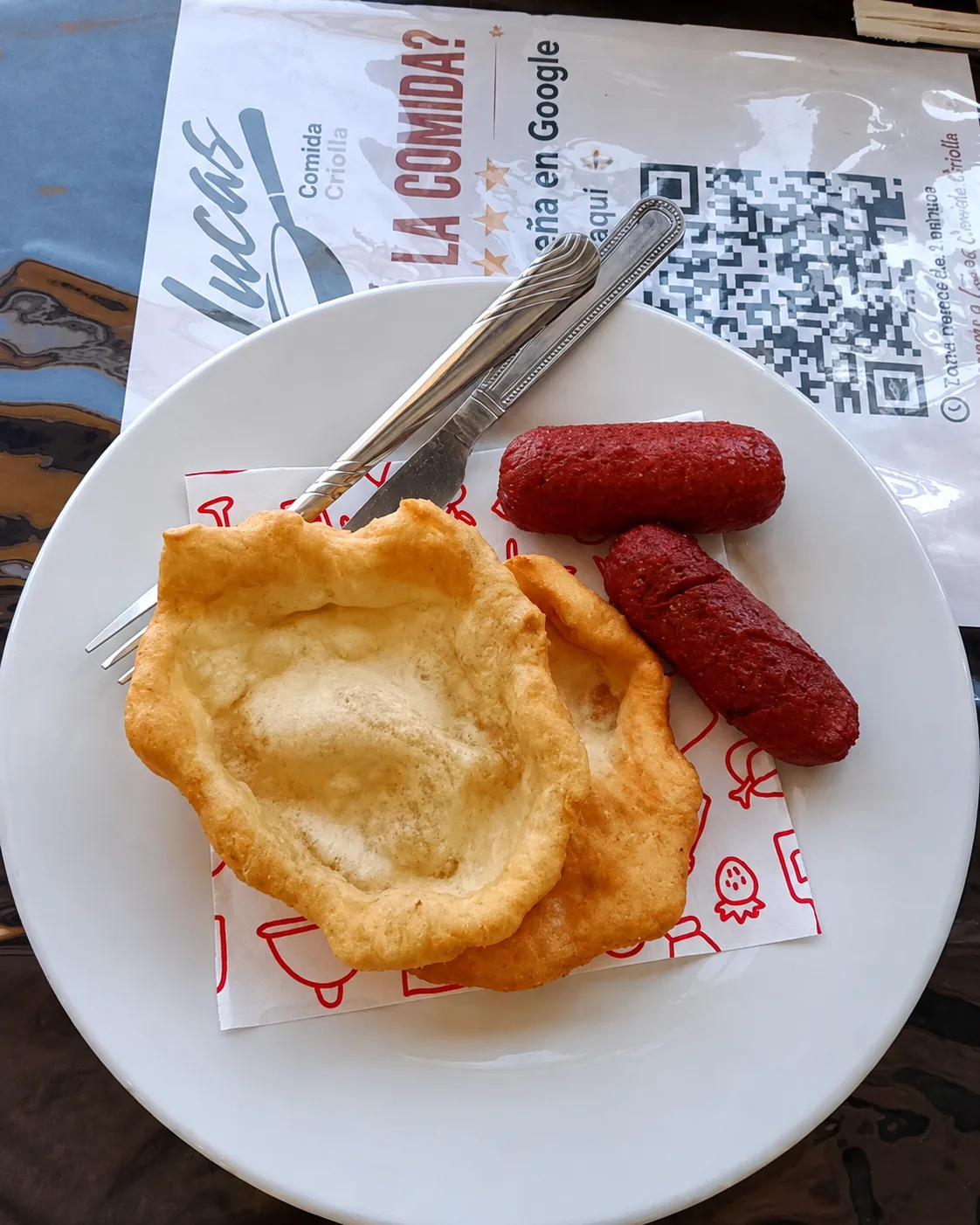 Hojaldres fritas con salchichas servidas en un plato blanco.