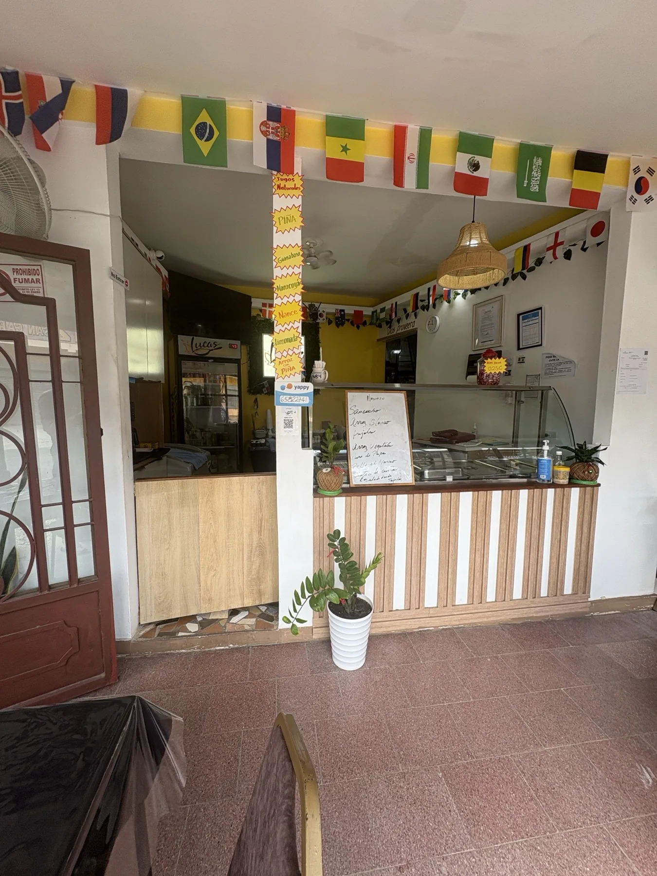 Mostrador de servicio de Lucas Comida Criolla con menú y bandejas cubiertas.